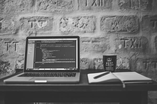 A computer and a notebook on a desk